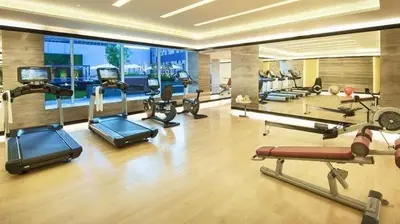 a gym with several cardio machines in a room at DAMAC 1BHK Apt Business Bay Dubai with Pool & Canal Walk in Dubai