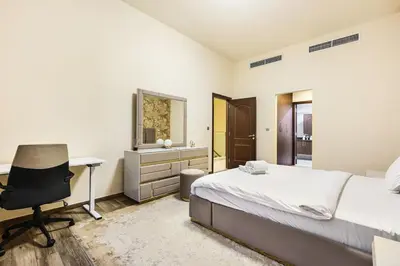 a bedroom with a bed and a desk and a chair at Stylish 4BR Family Villa Easy Access to Dubai Marina & Expo City in Dubai