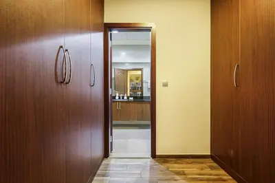a hallway with two wooden doors and a kitchen at Stylish 4BR Family Villa Easy Access to Dubai Marina & Expo City in Dubai