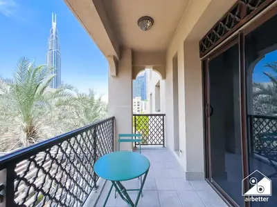 a balcony with a blue table and a view of the city at Burj Views from Balcony l Chic 2BR in Downtown in Dubai