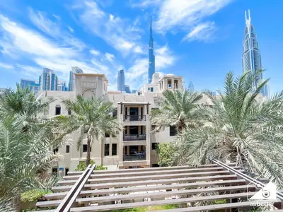 a building with palm trees in front of a city at Burj Views from Balcony l Chic 2BR in Downtown in Dubai