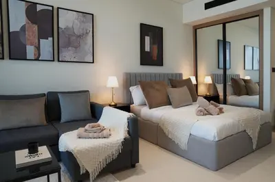 a living room with a couch and a bed at Lux Business Bay Studio with Jacuzzi & Canal View in Dubai