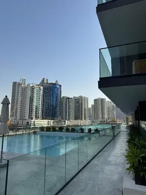 a building with a swimming pool with a city at Lux Business Bay Studio with Jacuzzi & Canal View in Dubai