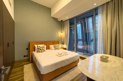 a bedroom with a bed and a glass table at Modern Living with Canal Views, Near Burj Khalifa and World Trade Center in Dubai