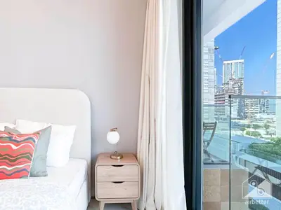 a bedroom with a bed and a balcony with a view at Luxury & City Views Studio in Azizi Riviera in Dubai