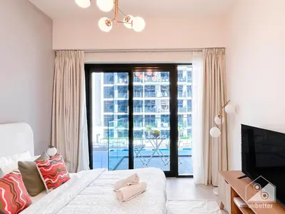 a bedroom with a bed and a sliding glass door at Luxury & City Views Studio in Azizi Riviera in Dubai