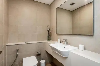 a bathroom with a sink and a toilet and a mirror at Luxury living , Triple pool access at Marina views in Dubai