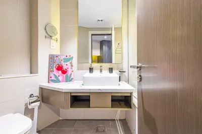 a bathroom with a white sink and a mirror at Elegant Studio Business Bay - Balcony with Skyline Views in Dubai