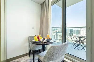 a dining room with a table and chairs and a window at Elegant Studio Business Bay - Balcony with Skyline Views in Dubai