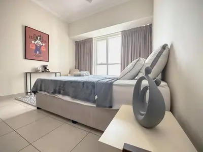 a bedroom with a large bed and a window at Stylish 1BR Apt with Canal Views in Dubai