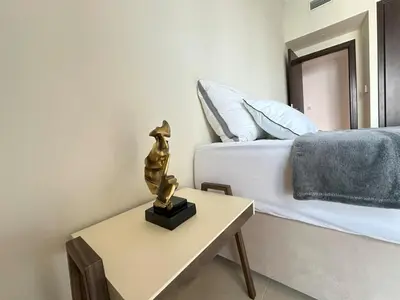 a bedroom with a bed and a table with a statue at Stylish 1BR Apt with Canal Views in Dubai