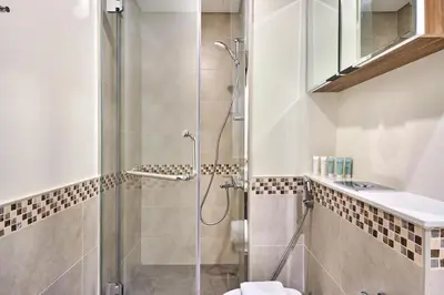 a bathroom with a glass shower with a toilet at Cozy 1BR Vera Tower with Amazing Burj Khalifa View in Dubai