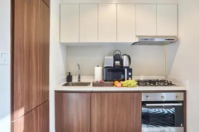a kitchen with a counter with a sink and a stove at Cozy 1BR Vera Tower with Amazing Burj Khalifa View in Dubai