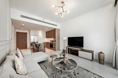 a living room with a white couch and a table at 2 BR, private beach access, sea view, Emaar beach front in Dubai