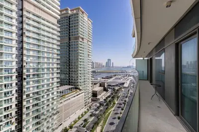 an apartment balcony with a view of a city at 2 BR, private beach access, sea view, Emaar beach front in Dubai