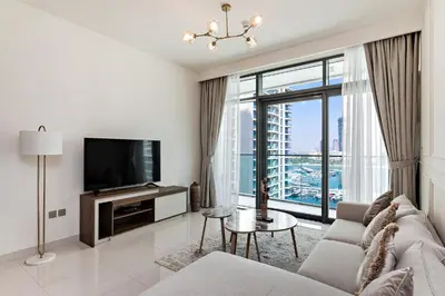 a living room with a couch and a tv at 2 BR, private beach access, sea view, Emaar beach front in Dubai