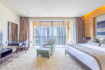 a hotel room with a large bed and a desk at SuperHost EMAAR Residences Fashion Avenue - Former Address Dubai Mall Studio's & 1 BR in Dubai