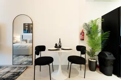 a dining room with a table and chairs and a mirror at Modern Studio in Elite Business Bay Residence in Dubai