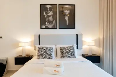a bedroom with two beds and two pictures on the wall at Modern Studio in Elite Business Bay Residence in Dubai