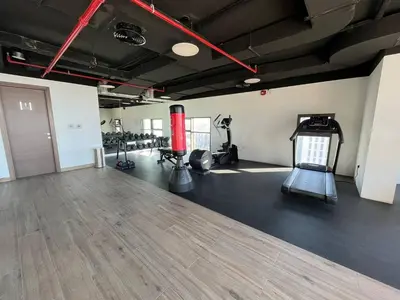 a fitness room with a treadmill and a gym at VacayLettings - 1 BHK - Near Jebel Ali Port- IKEA - Metro 20 Min - Al Furjan in Dubai