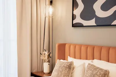 a bedroom with a bed with a lamp on a table at Experience Modern Comforts Near Iconic Dubai Mall and Burj Khalifa in Dubai