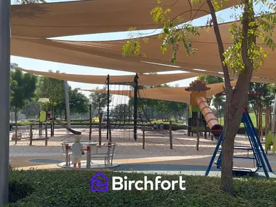 a playground with a slide and a swing at Birchfort - Elegant 1BR Furnished at Mulberry in Dubai