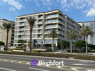 a large building with palm trees in front of a street at Birchfort - Elegant 1BR Furnished at Mulberry in Dubai