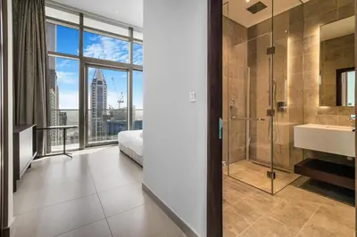 a bathroom with a shower and a bed and a sink at Marina Gate 2 Penthouse Iconic Views in Dubai