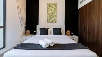 a bedroom with a large white bed with towels on it at 1br Luxury Complex Burj AlArab View 5min to beach in Dubai
