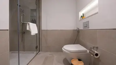 a bathroom with a toilet and a glass shower at 1br Luxury Complex Burj AlArab View 5min to beach in Dubai