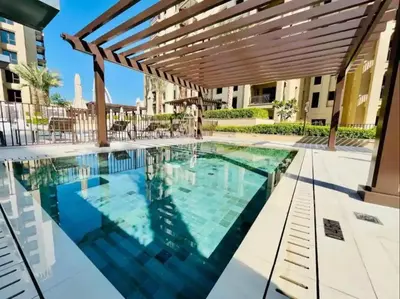 a swimming pool with a wooden pergola at 1br Luxury Complex Burj AlArab View 5min to beach in Dubai