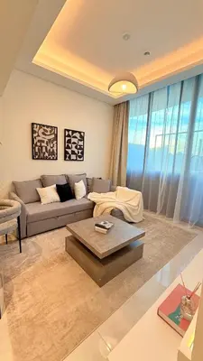 a living room with a couch and a table at Appartement de Luxe 1 Chambre avec Piscine Privée sur Balcon in Dubai