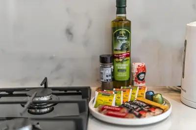 a plate of food on a stove with a bottle of wine at Elegant 1-Bed with Pool, Gym, Parking and Balcony in Dubai