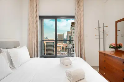 a bedroom with a white bed and a large window at Prime Location - Marina full View - Perfect for holidays in Dubai