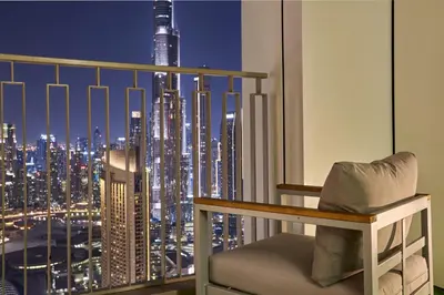 a room with a view of a city at night at Luxury 4 Bedroom High-Floor Apartment, Spectacular Burj Khalifa & Fountain Views, Steps Away from Dubai Mall - Downtown Dubai by Stayfinity in Dubai
