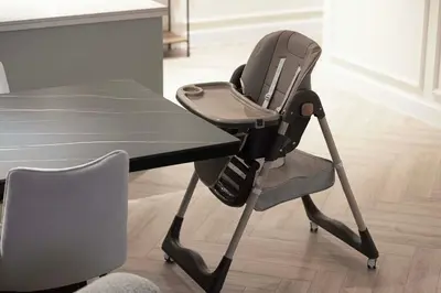 a high chair sitting next to a table at Spacious 4-Bedroom Apartment with Full Fountain and Burj Khalifa Views - 10 min Walk to Dubai Mall in Dubai