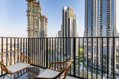 a balcony with two chairs and a view of the city at Alluring 1BDR apartment in Dubai Creek Harbour in Dubai