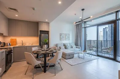 a kitchen and living room with a table and chairs at Alluring 1BDR apartment in Dubai Creek Harbour in Dubai