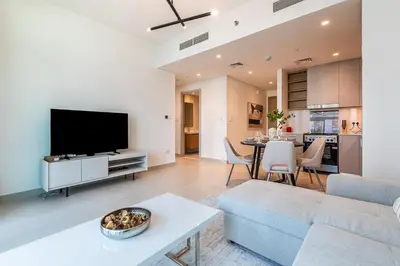 a living room with a couch and a tv at Alluring 1BDR apartment in Dubai Creek Harbour in Dubai