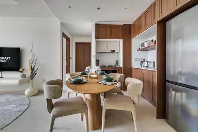 a kitchen and dining room with a wooden table and chairs at Elegant 1BR Apartment with Private Beach Access! in Dubai