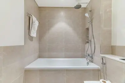 a bathroom with a shower with a bath tub at Elegant 1BR Apartment with Private Beach Access! in Dubai