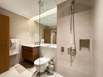 a bathroom with a shower and a toilet and a sink at Chic 1BR on La Mer Upgraded & Elegant in Dubai