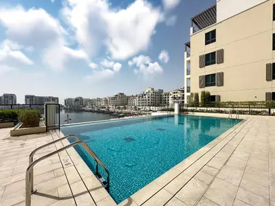 a swimming pool on the roof of a building at Chic 1BR on La Mer Upgraded & Elegant in Dubai