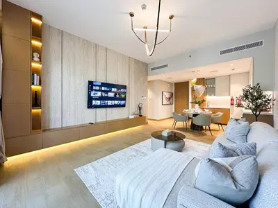 a living room with a couch and a tv at Chic 1BR on La Mer Upgraded & Elegant in Dubai