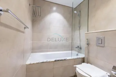 a bathroom with a bath tub and a toilet at 2BR with Balcony Overlooking City and Burj Khalifa, Minutes Away from Dubai Mall, Paramount Tower Hotel and Residences, Business Bay by Deluxe Holiday Homes in Dubai