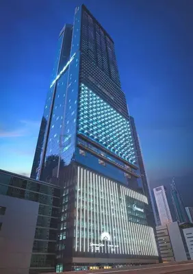 a tall building with blue lights on it at 2BR with Balcony Overlooking City and Burj Khalifa, Minutes Away from Dubai Mall, Paramount Tower Hotel and Residences, Business Bay by Deluxe Holiday Homes in Dubai