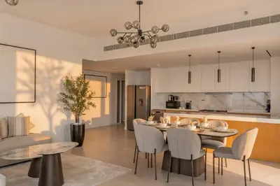 a kitchen and living room with a table and chairs at La Vie Jumeirah Beach Residence 3 Bedroom Beachfront Apartment with Palm Views in Dubai