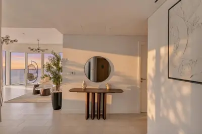 a dining room with a table and a mirror at La Vie Jumeirah Beach Residence 3 Bedroom Beachfront Apartment with Palm Views in Dubai