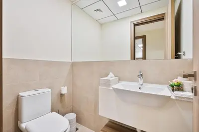 a bathroom with a white toilet and a sink at Modern 2BR with Private Terrace, Pool and Gym Access in Dubai