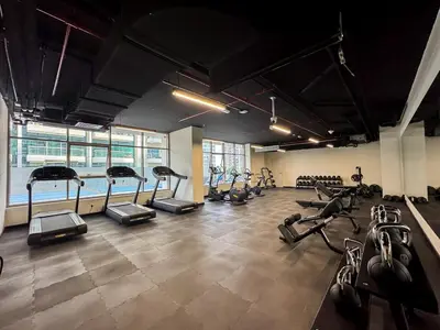 a gym with several treadmills and exercise bikes at Modern 2BR with Private Terrace, Pool and Gym Access in Dubai